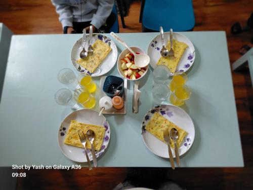 a table with plates of food and bowls of fruit at Valley Mist rooms & kitchen in Ravangla