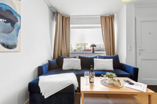 a living room with a blue couch and a table at Stylisches 2-Zimmer Ambient Apartment in Alsternähe mit Kingsize-Bett & Schlafsofa in Hamburg