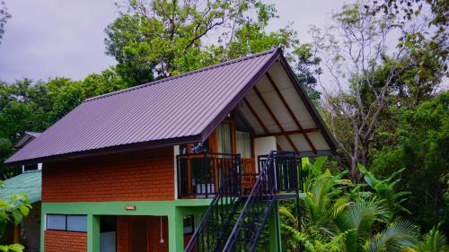 a small house with a black roof at Sigiri SAAT Cabana in Sigiriya