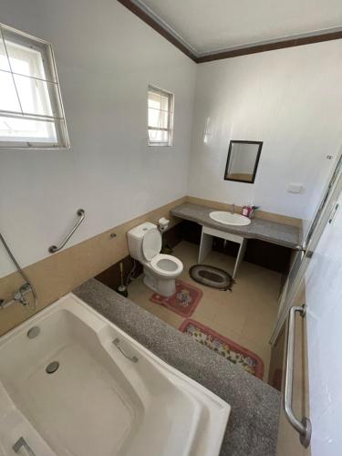 a bathroom with a tub and a toilet and a sink at JTJ Guest House in Bantay