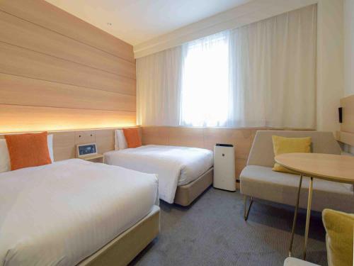 Postel nebo postele na pokoji v ubytování Nishitetsu Inn Shinjuku