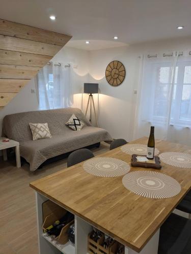 Cette chambre comprend un lit et une table avec une bouteille de vin. dans l'établissement L'ecrin d'Alsace, à Kintzheim