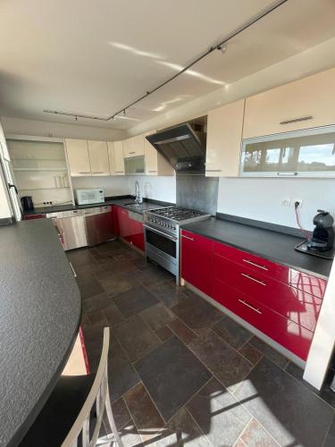 a kitchen with red cabinets and a black counter top at ibis Styles Bethune Bruay la Buissière in Bruay-la-Buissiere