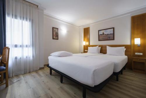 a hotel room with two beds and a window at Crisol Almería in Almería