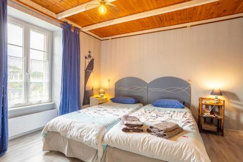 a bedroom with a large bed with blue pillows at La ferme de séjour du Cosquer in Beuzec-Cap-Sizun