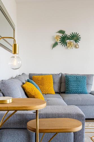 - un salon avec un canapé gris et des oreillers jaunes dans l'établissement Panoramic vue cassis, à Cassis