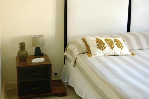 a bed with a pillow and a nightstand with a lamp at Hôtel La Boulangerie in Grimaud