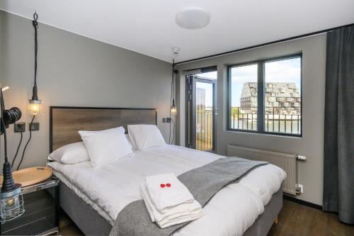 a bedroom with a large bed and a window at Blomlöfs Hotell Saltö in Karlskrona