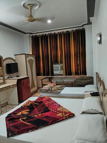 a hotel room with two beds and a desk at Hotel Yatri International in New Delhi