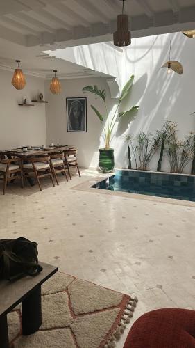 a large room with wooden tables and potted plants at Riad Reflet D'orient Marrakech in Marrakech