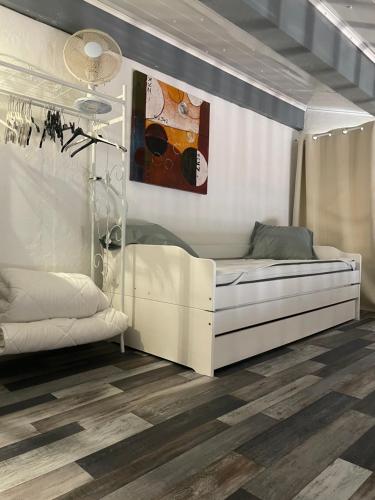 - une chambre avec un lit blanc et un tableau dans l'établissement Marseillan plage maison avec jardin, à Marseillan