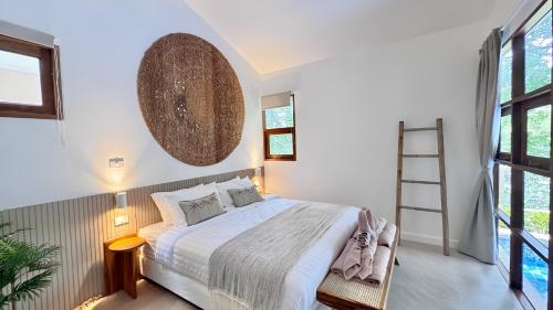 a white bedroom with a bed and windows at Villa La Golden Monkey, Villa 24 in Chaweng Noi Beach
