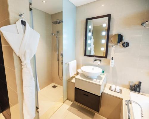 a bathroom with a sink and a shower at Southern Sun Abu Dhabi in Abu Dhabi