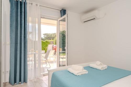 a bedroom with a blue bed and a balcony at Villa Carlotta in Zadar