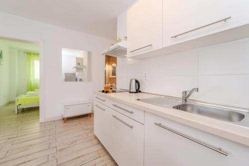 a kitchen with white cabinets and a sink at Villa Carlotta in Zadar