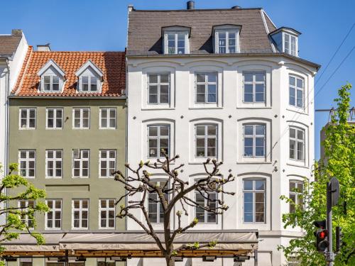 a large white building with a tree in front of it at Sanders Regent Bright 1 Bdr Apt in Copenhagen