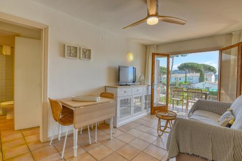a living room with a couch a table and a tv at Penyagolosa in Calella de Palafrugell