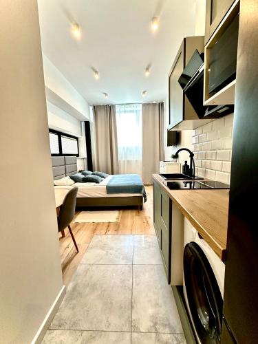 a kitchen and living room with a bed in a room at BOOGIE Home Kamienica Łódzka in Łódź