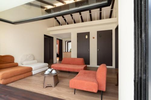 a living room with orange chairs and a couch at Boro Hanok Hostel in Myeongdong in Seoul