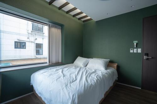 a bedroom with a large bed with a window at Boro Hanok Hostel in Myeongdong in Seoul