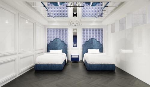 two beds in a room with blue and white walls at The Siena PRIMO in Seogwipo
