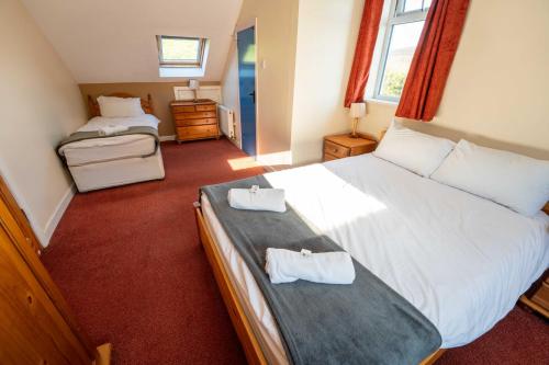 a bedroom with a large bed with two towels on it at Aras Ghleann Cholm Cille in Glencolumbkille
