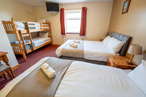 a room with two beds and a bunk bed at Aras Ghleann Cholm Cille in Glencolumbkille
