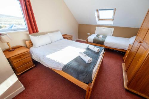 a bedroom with two beds and a window at Aras Ghleann Cholm Cille in Glencolumbkille