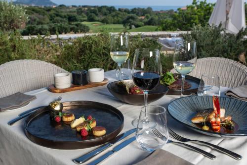 a table with plates of food and glasses of wine at The Westin Resort, Costa Navarino in Romanós