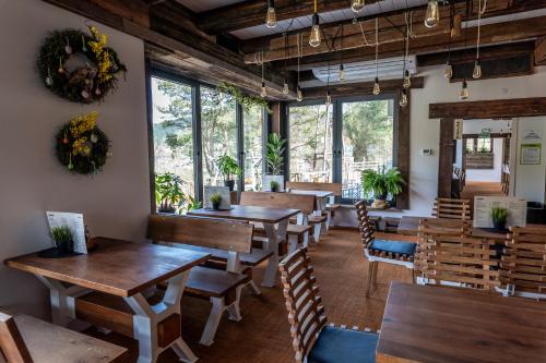 Un restaurante con mesas y sillas de madera y ventanas. en Słotwiny Arena, en Krynica-Zdrój