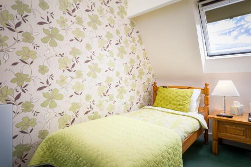 a bedroom with a bed and a flowery wallpaper at Arden Park Ensuite Rooms in Stratford-upon-Avon