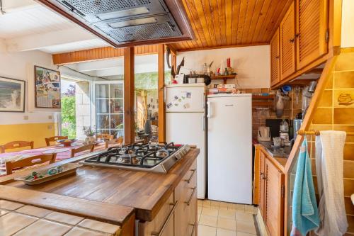 une cuisine avec une cuisinière et un réfrigérateur dans l'établissement La ferme de séjour du Cosquer, à Beuzec-Cap-Sizun