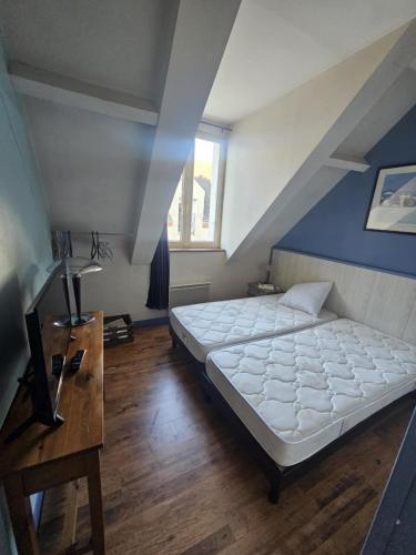 a bedroom with a large bed and a blue wall at Le petit carrousel in Sully-sur-Loire