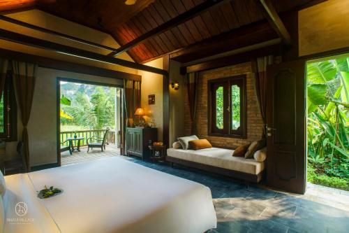 un soggiorno con letto e patio di Nham Village Resort a Ninh Binh