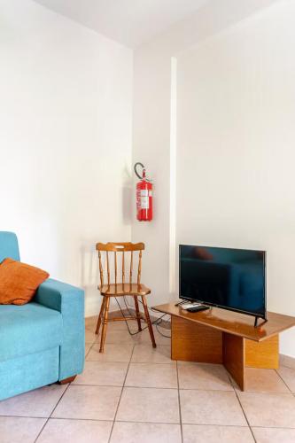 a living room with a blue couch and a table with a tv at Villa Varo by Sicily Travelling Villas in Scopello