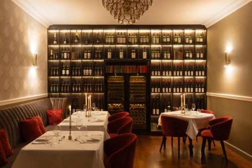 a restaurant with two tables and a large wall of wine bottles at Schloßhotel Althörnitz in Bertsdorf