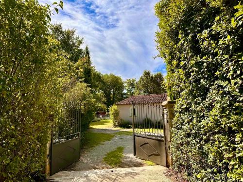an entrance to a garden with a gate and trees at Mon Gîte en Provence avec piscine in Salernes