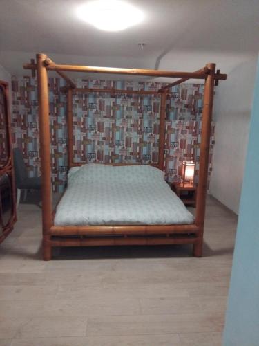 a bed with a wooden frame in a room at Villas Paradis in Saint-Paul-lès-Dax