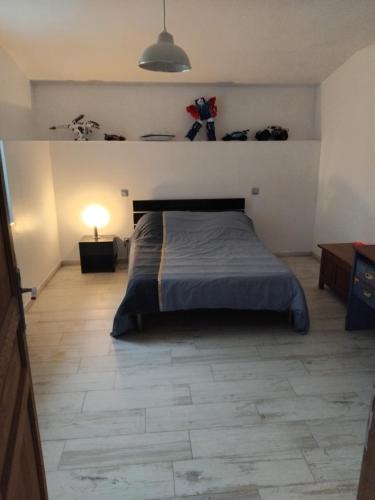 a bedroom with a bed and a lamp on a tiled floor at Villas Paradis in Saint-Paul-lès-Dax