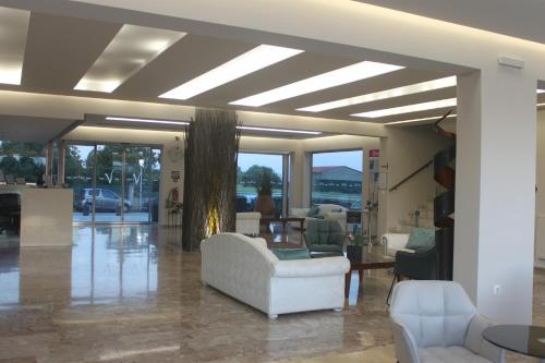 a living room with a white couch and chairs at Vallian Village Hotel in Paradeísion