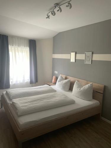 a large bed in a bedroom with a window at City House Alpeneck in Füssen