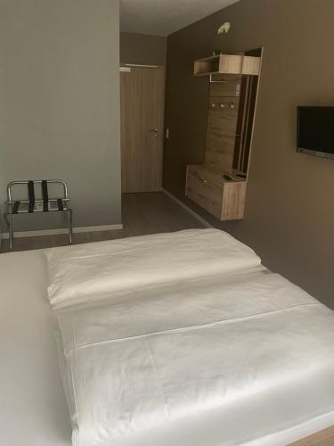 a white bed in a room with a mirror at City House Alpeneck in Füssen
