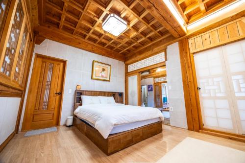 a bedroom with a bed and a wooden ceiling at Hanok Stay - JukRokJungSa in Gurye
