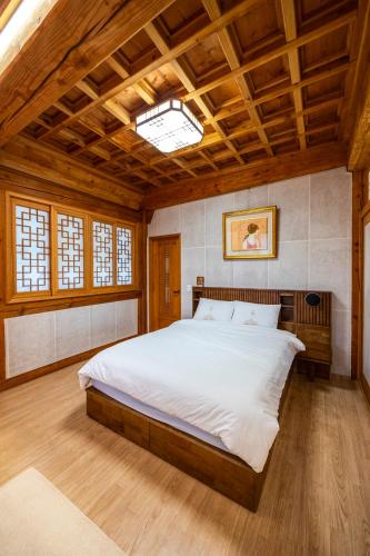 a bedroom with a large bed with a wooden ceiling at Hanok Stay - JukRokJungSa in Gurye
