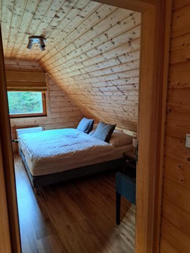 a bedroom with a bed in a wooden house at Chaty Pod Dlhou Podbanské in Pribylina