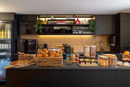 eine Theke mit Brot und anderen Lebensmitteln darauf in der Unterkunft Hotel Korner Sorbonne in Paris