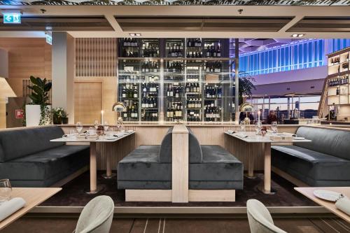 a restaurant with tables and couches and a bar at Gothia Towers & Upper House in Gothenburg
