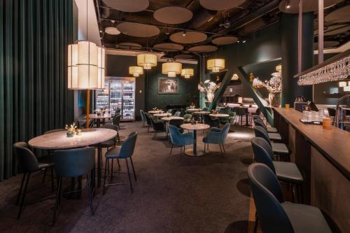 a restaurant with tables and chairs and a bar at Gothia Towers & Upper House in Gothenburg