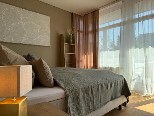 a bedroom with a bed and a large window at Apartment Fjordliebe, Lammplatz Bad Krozingen in Bad Krozingen