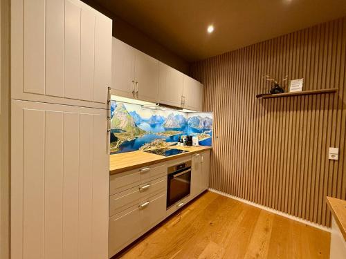 a kitchen with white cabinets and a painting on the wall at Apartment Fjordliebe, Lammplatz Bad Krozingen in Bad Krozingen